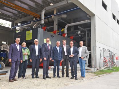 Geschäftsführer und ProkuristInnen der Fernwärme, EVN Vorstandsmitglieder und der Vizepräsident der EVN bei einem Gruppenfoto. Im Hintergrund sieht man die neue Anlage des FHK Nord in St. Pölten