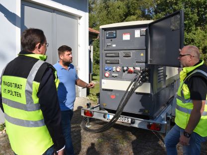 Drei Personen mit einem Notstromaggregat. (Foto: Vorlaufer)