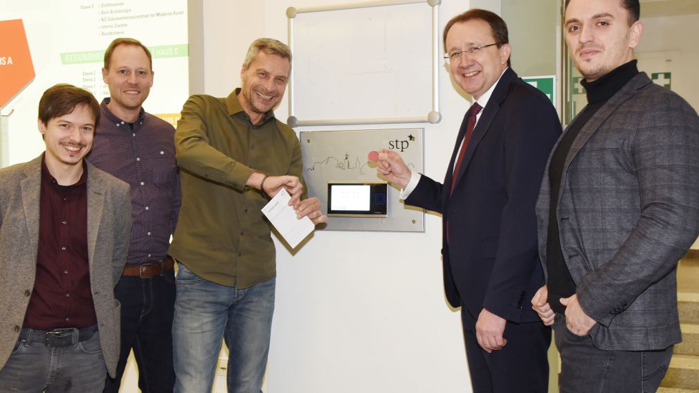 Fünf Personen vor dem neuen Zeiterfassungs-Terminal. (Foto: Vorlaufer)