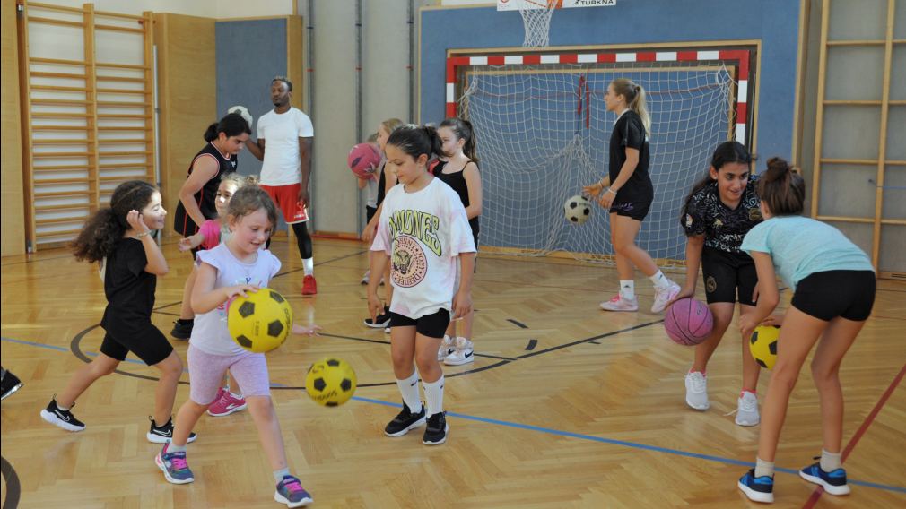 Kinder die Basketball spielen.
