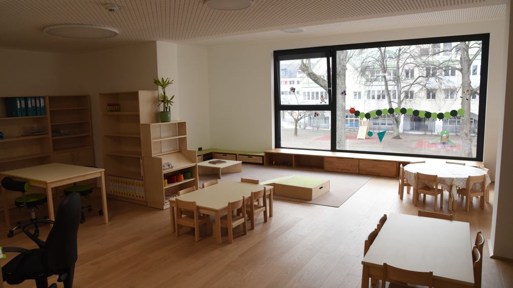 Bürgermeister Matthias Stadler, Baumeister Markus Steinwendtner, Kindergartenleiterin Marion Gnigler und Schulamtsleiter Andreas Schmidt sitzen im neuen Kindergarten mit zwei Kindern. (Foto: Vorlafuer)