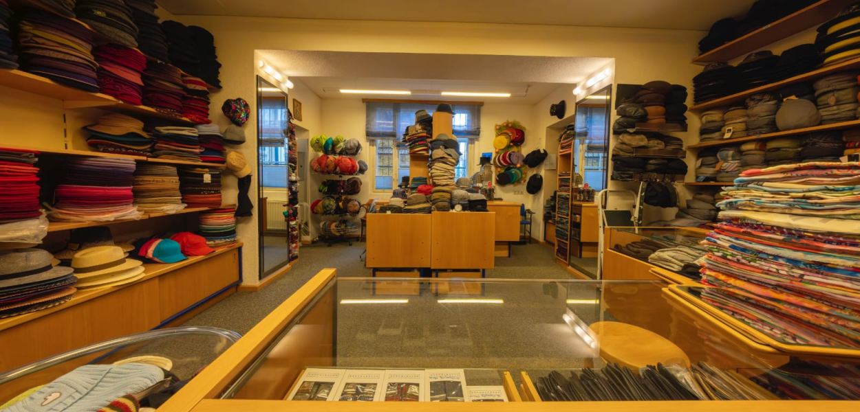 Modisten-Meisterin Anna Öckher vor Regalen voll mit bunten Hüten in ihrem St. Pöltner Geschäft. Foto: Althea Müller