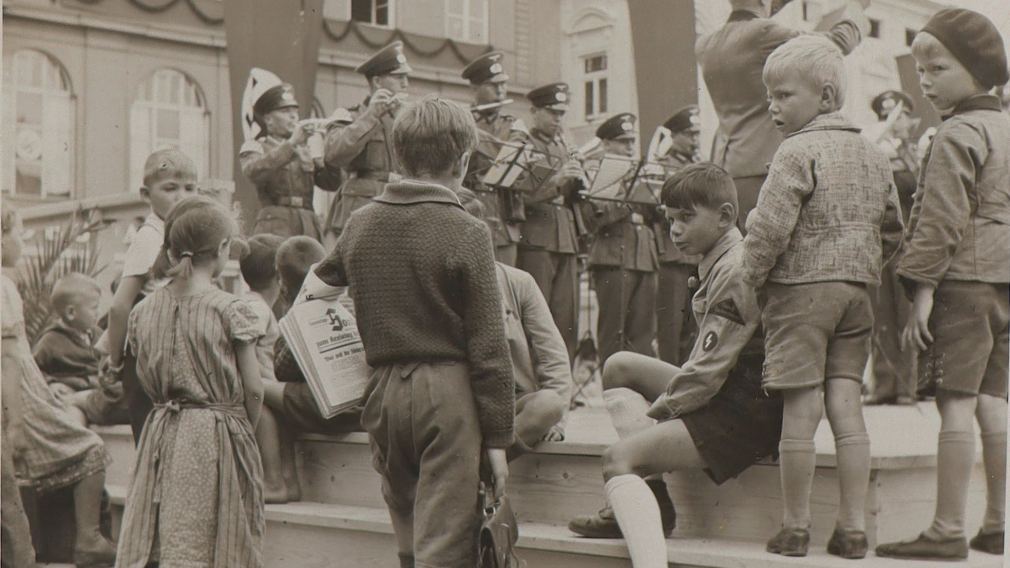 Fotografie von Kindern am Rathausplatz mit der Sonderausgabe des „St. Pöltner Anzeiger“ zum Kreistag der NSDAP, 1939. (Foto: Privatbesitz)