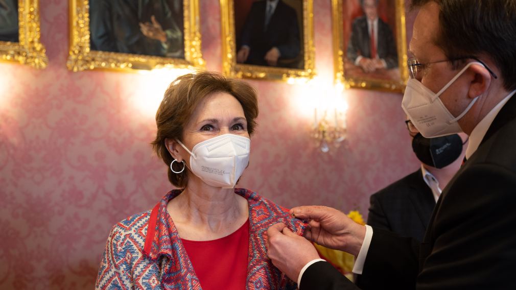 Bürgermeister Matthias Stadler steckt die Nadel mit dem Ehrenzeichen der Stadt St. Pölten an das Jackett von Eleonora Brandstetter an. 