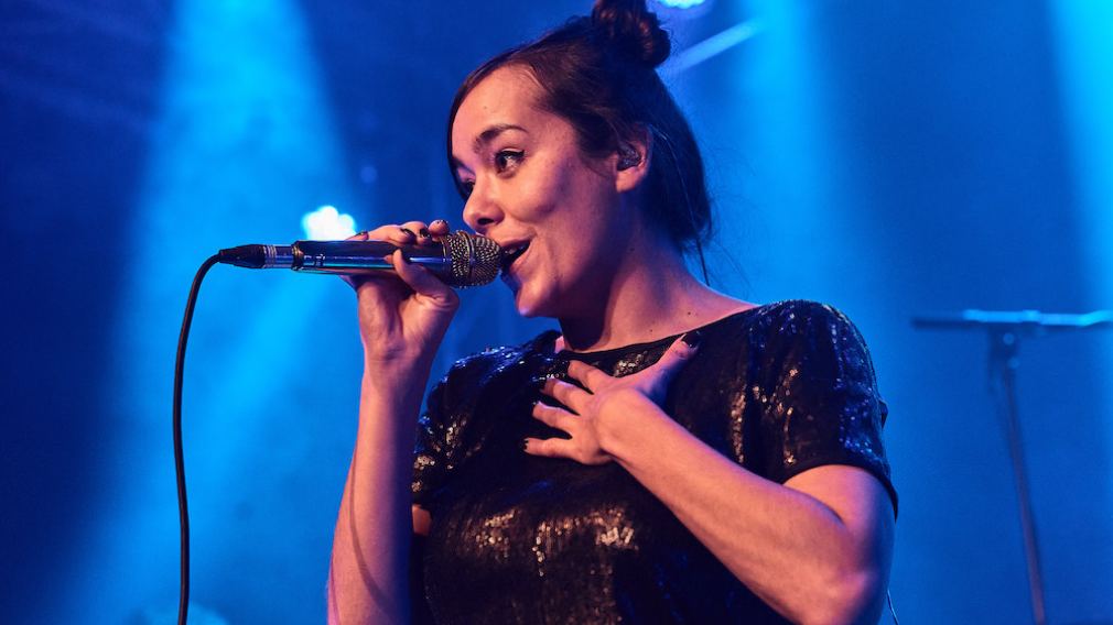 10 Mitarbeiter:innen vom Team vom Freiraum St. Pölten auf der Bühne vor rotem Vorhang. Foto: Klaus Engelmayer