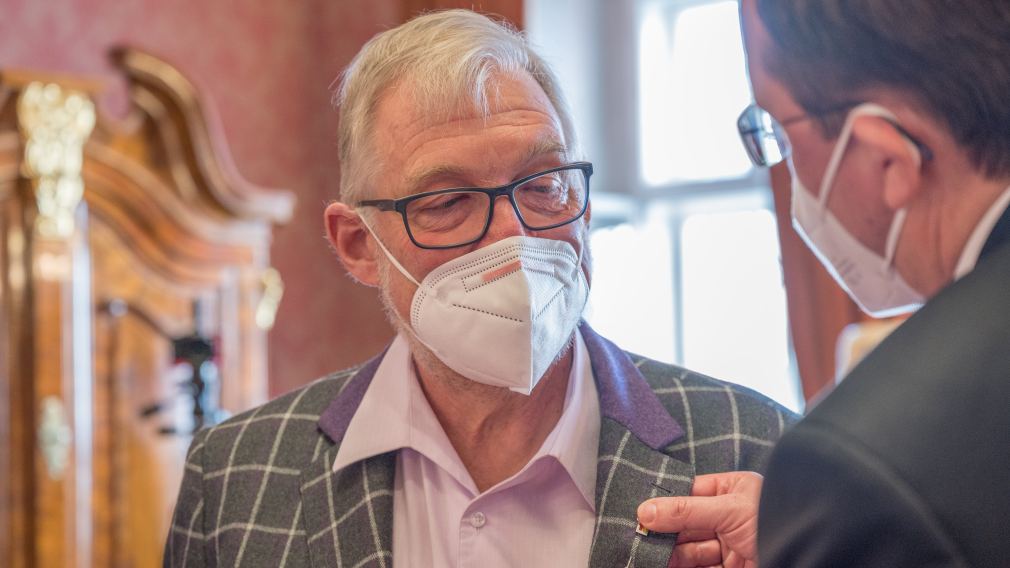 Bürgermeister Matthias Stadler steckt die Nadel mit dem Ehrenzeichen der Stadt St. Pölten an das Jackett von Dr. Harald Mayr an. 