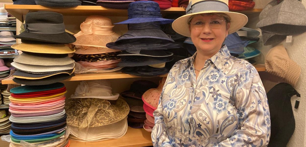 Modisten-Meisterin Anna Öckher vor Regalen voll mit bunten Hüten in ihrem St. Pöltner Geschäft. Foto: Althea Müller