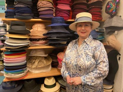 Modisten-Meisterin Anna Öckher vor Regalen voll mit bunten Hüten in ihrem St. Pöltner Geschäft. Foto: Althea Müller